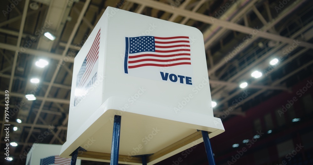 Voting booth with American flag logo at polling station. National Election Day in the United States of America. Presidential race and elections coverage. Civic duty, patriotism and democracy concept.