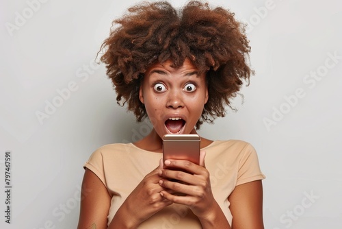 Surprised african american woman reading shocking message on mobile phone screen