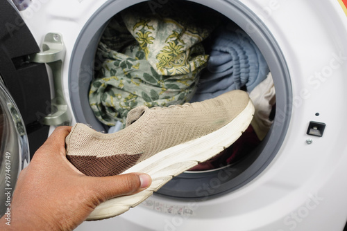  putting dirty shoe in a washing machine. © Towfiqu Barbhuiya 