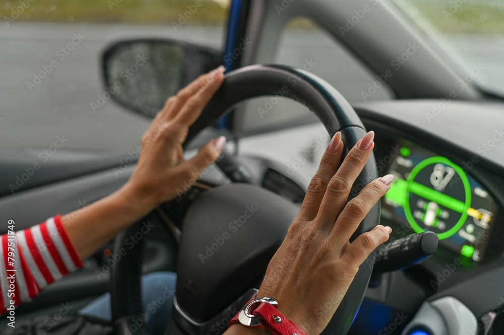 women's hands on the steering wheel. concept
