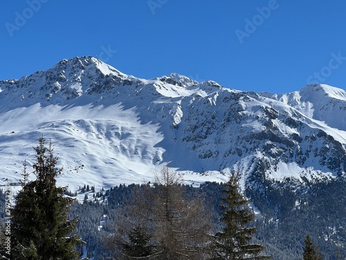 Beautiful sunlight and snow-capped alpine peaks above the Swiss tourist sports-recreational winter resorts of Valbella and Lenzerheide in the Swiss Alps - Canton of Grisons  Switzerland  Schweiz 