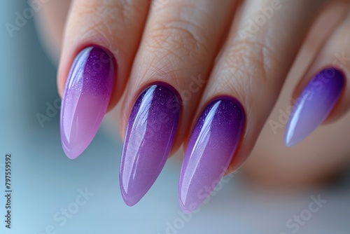 Woman hand with lavender color nail polish on her fingernails. Purple nail manicure with gel polish at luxury beauty salon. Nail art and design. Female hand model. 