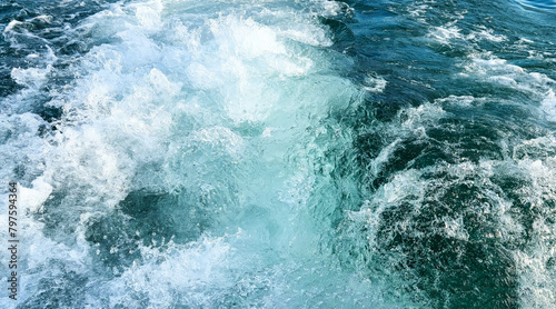 Sea water with foamy surface close-up. Boat trip on Lake Garda. Top view of turquoise rushing water. Foamy trail from a boat. Selective focus