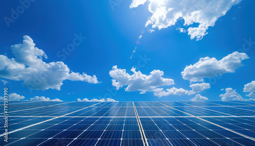Des panneaux solaires photovoltaïque sous un ciel bleu avec des rayons de soleil et des nuages. photo