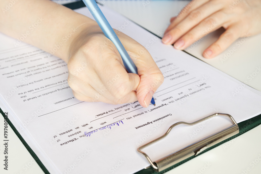 Commission agreement, hand fills out a document, business transaction, financial services, legal paperwork Commission agreement, hand fills out a document, business transaction, financial services, legal paperwork