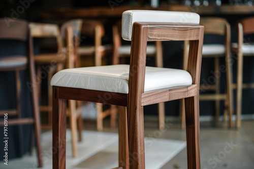 A barstool chair with a white seat and a wooden frame featuring a ladder-back design