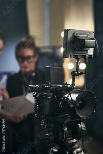 Vertical background image of pro digital video camera set up on stand in video production studio copy space