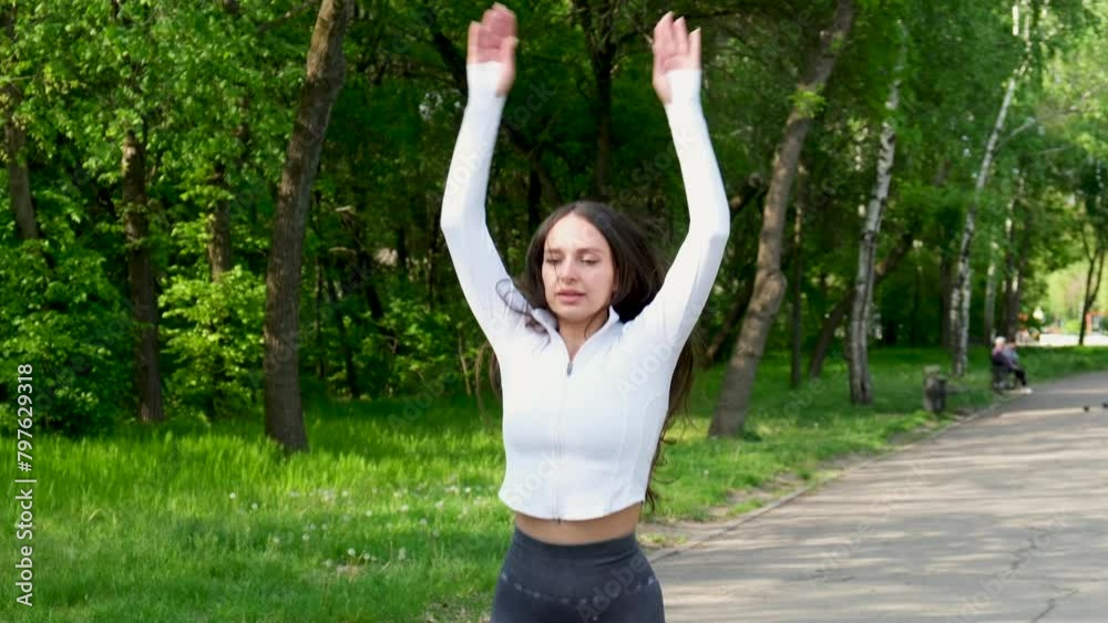 Cute fit young girl doing warming up stretching on nature. Sport fitness. Flexibility exercise training. Gymnastics girls make warming up stretching outdoor in park Cute fit young girl doing warming up stretching on nature. Sport fitness. Flexibility exercise training. Gymnastics girls make warming up stretching outdoor in park