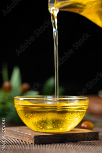 pouring olive oil into a glass bowl on table.