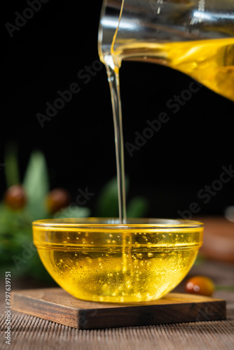 pouring olive oil into a glass bowl on table. © zhikun sun