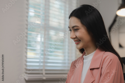 Free Download A beautiful young Asian woman is happily sitting in a private office. The atmosphere in a private office with female employees sitting in the room with smiles on their faces. - GFXLoad