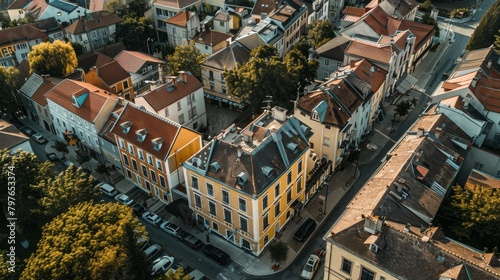 Aerial view of a small town with a distinctive, unusual building in soft yellows, standing out among more muted town colors