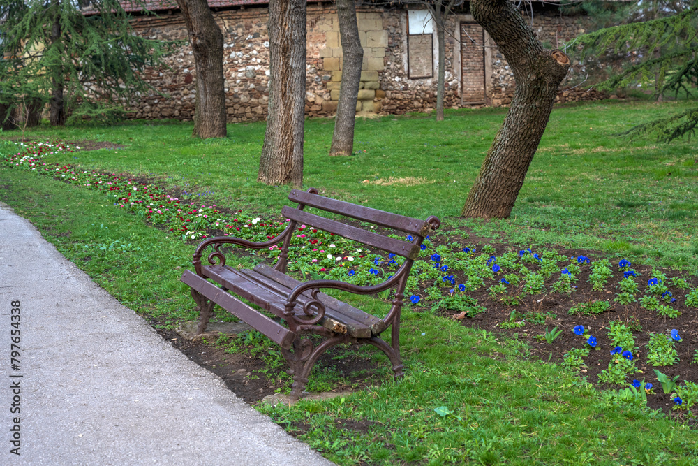 Brown benches for sitting in the city park surrounded by greenery and flowers. Benches for rest and relaxation. Next to the benches there are concrete paths for sitting and running.
Brown benches for sitting in the city park surrounded by greenery and flowers. Benches for rest and relaxation. Next to the benches there are concrete paths for sitting and running.
