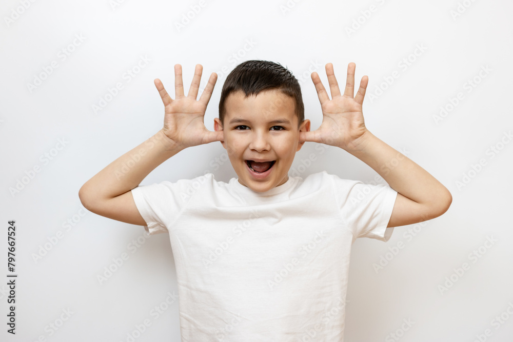 The guy raised his hands to his ears, shows a funny face. Sincere children's emotions. The guy raised his hands to his ears, shows a funny face. Sincere children's emotions.