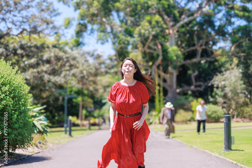 公園を走る赤いドレスを着た女性