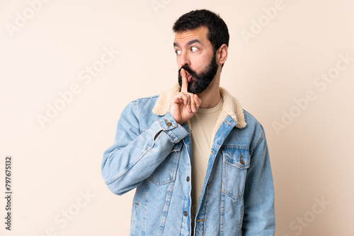 Caucasian man with beard over isolated background showing a sign of silence gesture putting finger in mouth