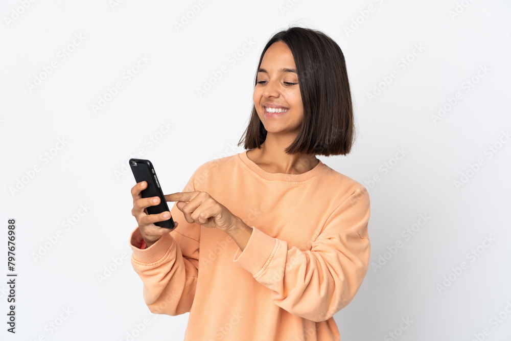 Young latin woman isolated on white background sending a message or email with the mobile Young latin woman isolated on white background sending a message or email with the mobile