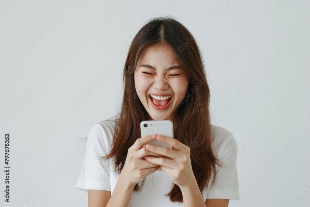 Asian woman celebrates online win with excitement and joy. Asian woman celebrates online win with excitement and joy.