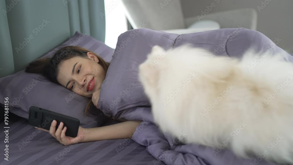Pretty woman is playing her smart phone after wake up. Pretty woman is playing her smart phone after wake up.