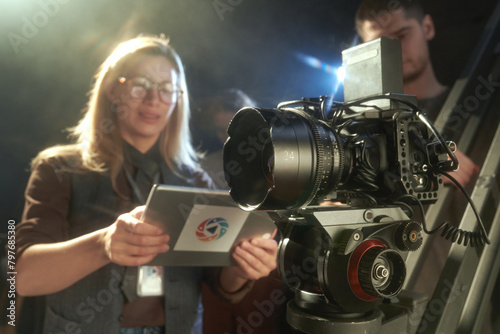 Pro video camera with female director overseeing video production, copy space photo
