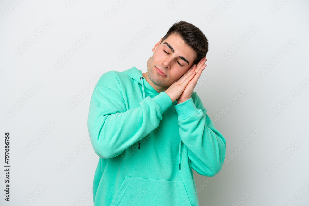 Young caucasian man isolated on white background making sleep gesture in dorable expression Young caucasian man isolated on white background making sleep gesture in dorable expression