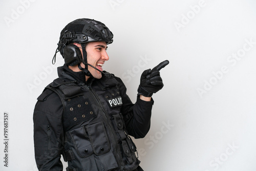 SWAT caucasian man isolated on white background pointing finger to the side and presenting a product