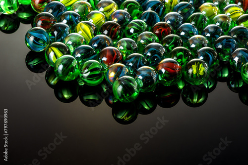 Colorful glass marbles with reflection on a black glass background.