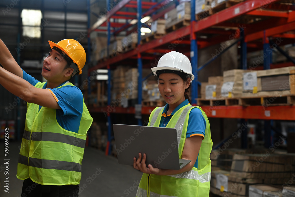 Two Warehouse employees check and count the stock inventory on a laptop, a Smart Warehouse management concept