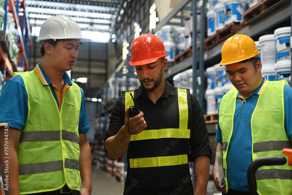 Warehouse manager and team using a walkie-talkie to communication for checking inventory Warehouse manager and team using a walkie-talkie to communication for checking inventory