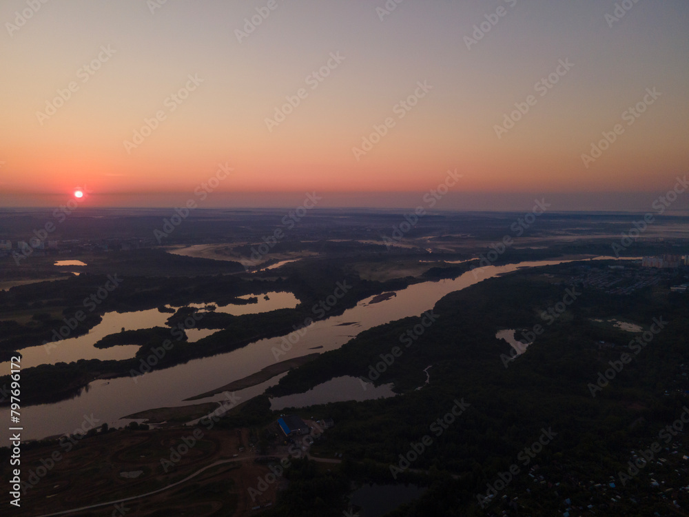 Peaceful place at the sunset with long river and green forest