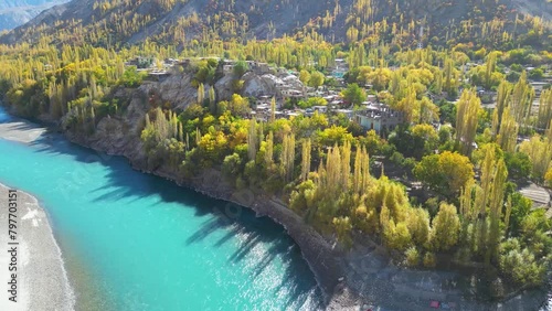 Drone shot over Skardu in pakistan turquoise river and green trees with mountains in the background photo