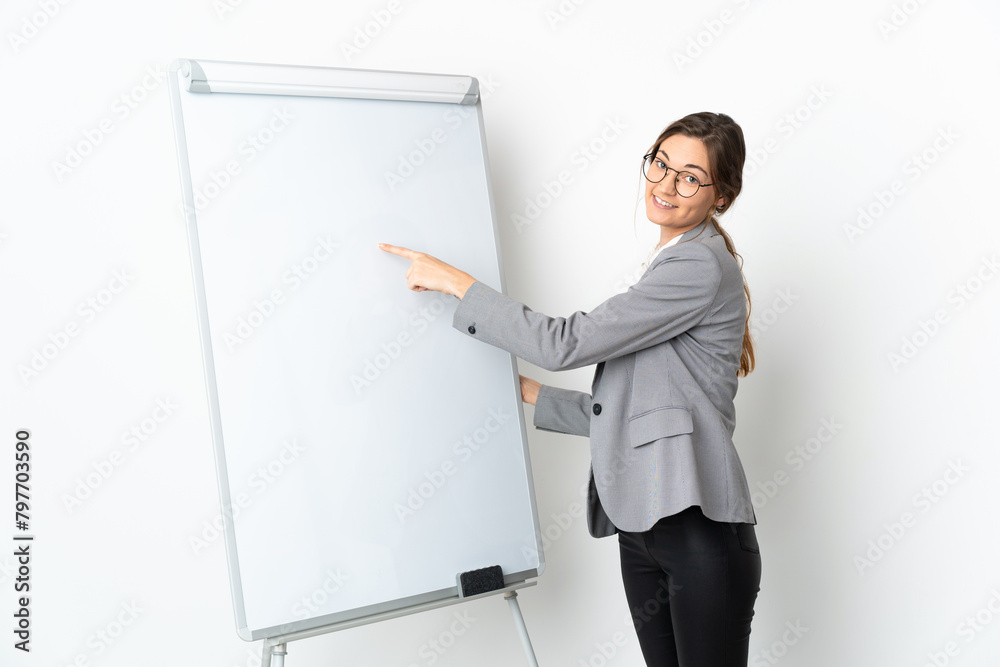 Young Ireland woman isolated on white background giving a presentation on white board and writing in it Young Ireland woman isolated on white background giving a presentation on white board and writing in it