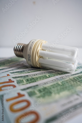Light bulb with 100 usd note bills , Increase in electricity tariffs