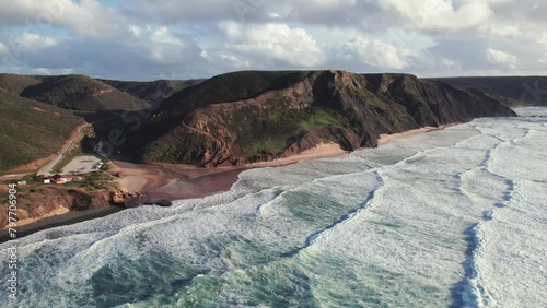 Aerial 4k drone establishing shot of continuous waves at praia da Cordoama hidden cliff coastline near the Algarve region of Portugal photo