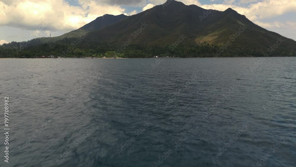 Low level flight over the ocean with tilt up reveal flying towards Sabang boat terminal.