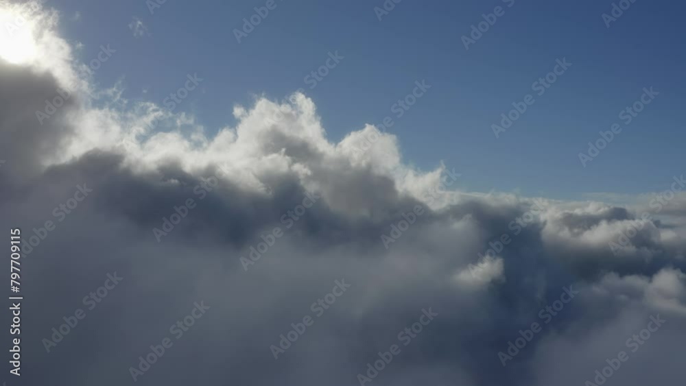 Sunlight diffuses light between thick white fluffy cloudscape texture, aerial dolly Sunlight diffuses light between thick white fluffy cloudscape texture, aerial dolly
