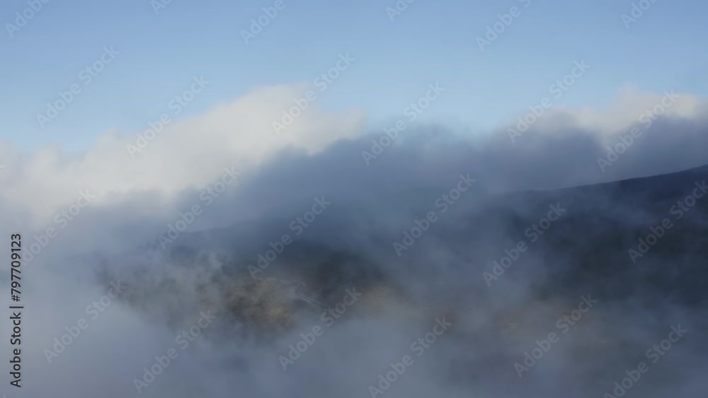 Wispy clouds rise pushing across slopes of Haleakala, aerial overview Wispy clouds rise pushing across slopes of Haleakala, aerial overview
