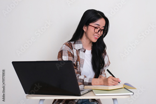 Female college student showing happy face when doing her homework photo