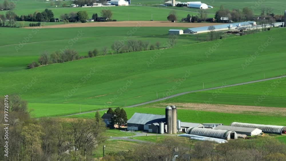 Drone wide shot showing many farms in rural area of Illinois, USA. Beautiful sunny day with green fields and hills in America. Drone wide shot showing many farms in rural area of Illinois, USA. Beautiful sunny day with green fields and hills in America.