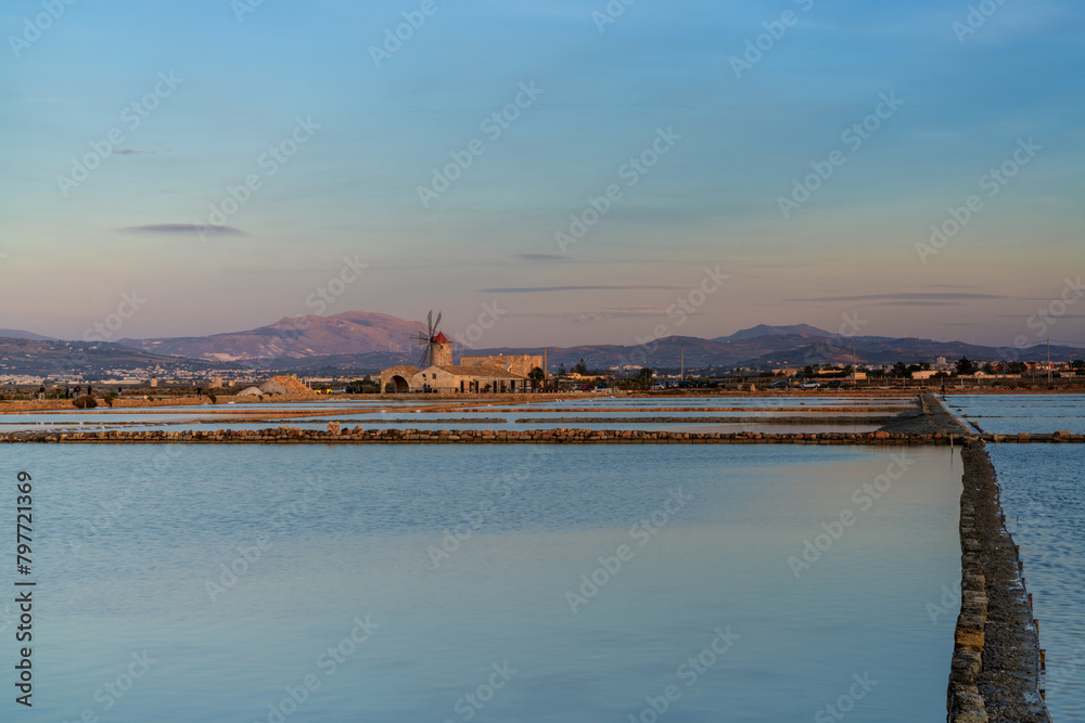 Fototapeta premium view of the windmill and salt flat museum of Paceco at sunset