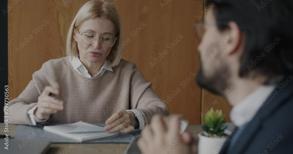 Experienced therapist working with male client depressed businessman talking and writing in office. Therapy session and professional communication concept.