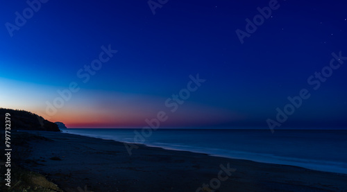 Sunrise, waves and the stars at the Yanışlı beach on the background of  reddish sky and Mediterranean Sea © cemkurtulus