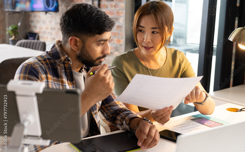 © Wavebreak Media - Asian mature woman and young man review documents in office