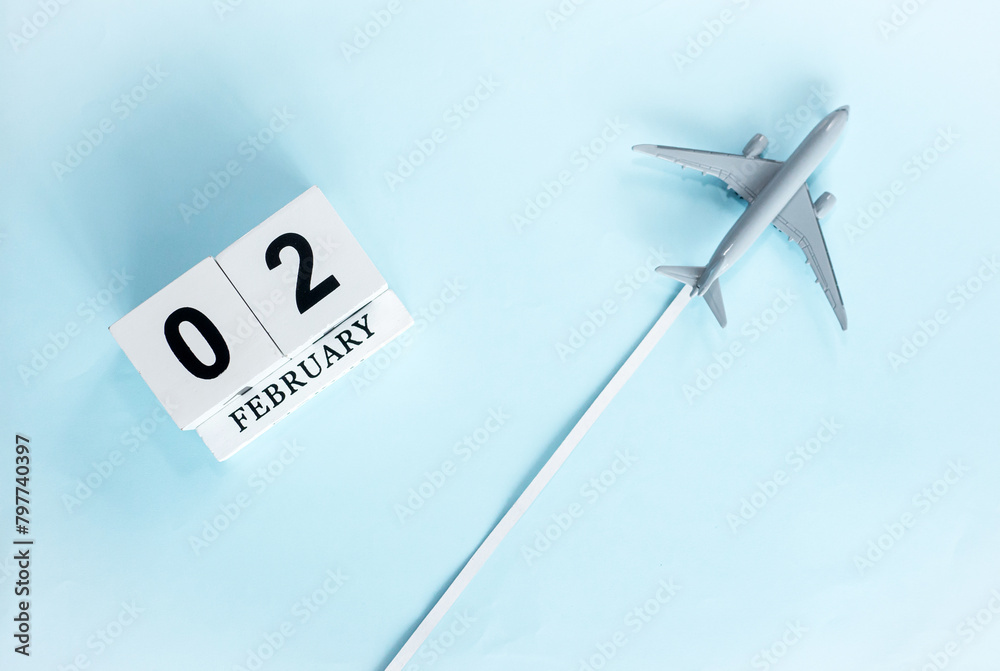 February calendar with number 2. Top view of calendar with flying passenger plane. Scheduler. Travel concept. Copy space. February calendar with number 2. Top view of calendar with flying passenger plane. Scheduler. Travel concept. Copy space.