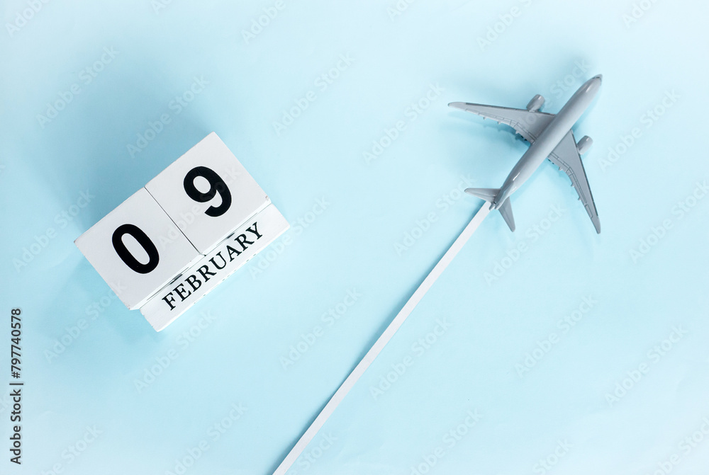 February calendar with number 9. Top view of calendar with flying passenger plane. Scheduler. Travel concept. Copy space. February calendar with number 9. Top view of calendar with flying passenger plane. Scheduler. Travel concept. Copy space.
