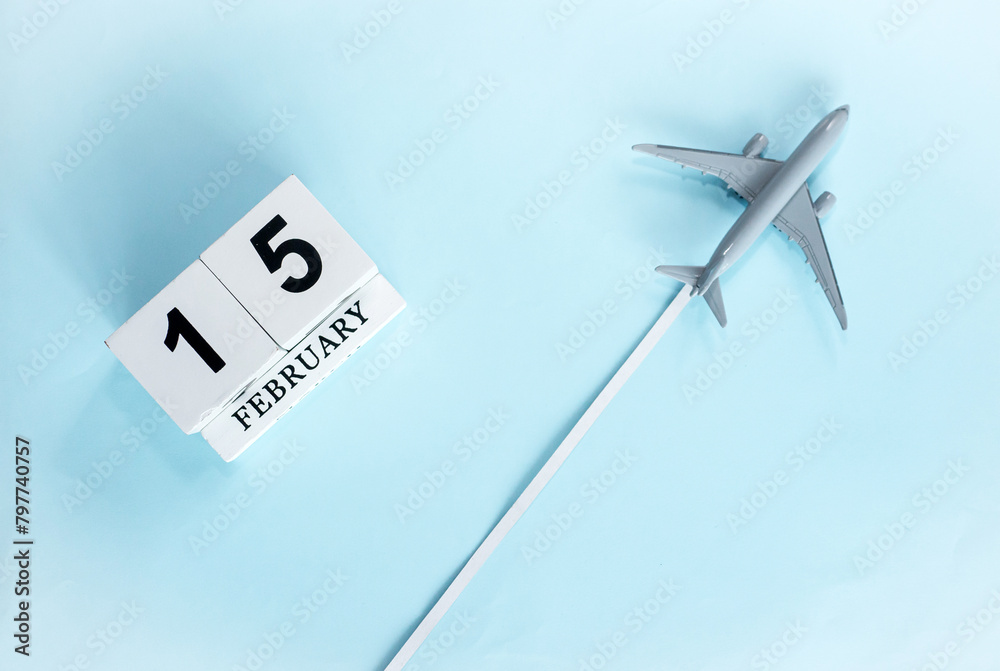 February calendar with number 15. Top view of calendar with flying passenger plane. Scheduler. Travel concept. Copy space. February calendar with number 15. Top view of calendar with flying passenger plane. Scheduler. Travel concept. Copy space.
