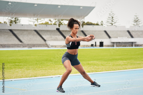 Woman, athlete and stretching on track field for running, training and fitness in summer. Professional sportswoman, runner and workout in stadium for wellness, cardio and warm up for marathon