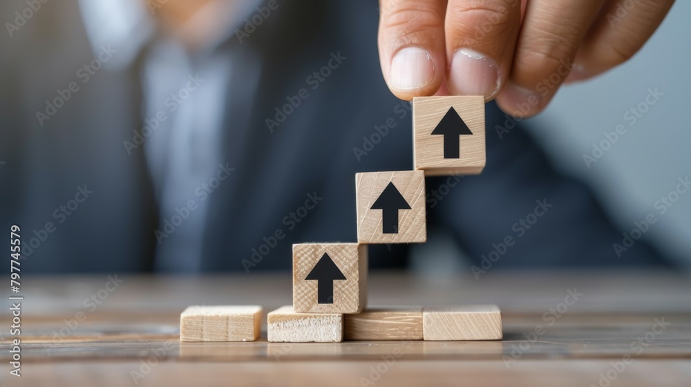 Wooden cubes in the shape of a ladder with a hand on isolated white background close-up. directional arrow sign. accelerate Wooden cubes in the shape of a ladder with a hand on isolated white background close-up. directional arrow sign. accelerate