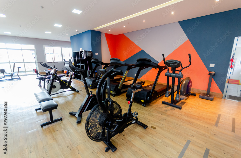 Fototapeta premium some black and orange exercise bikes and various exercise equipment and mirrors