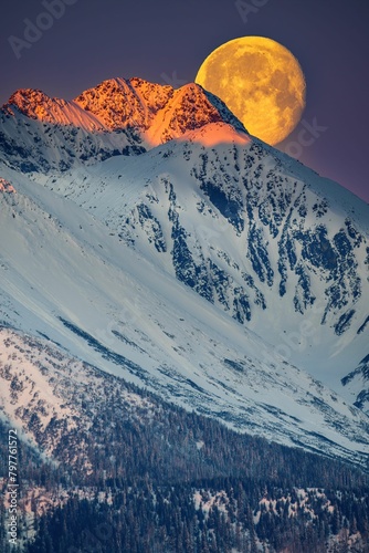 Fototapeta Naklejka Na Ścianę i Meble -  Ogromny księżyc w pełni zachodzi za Tatrami o poranku